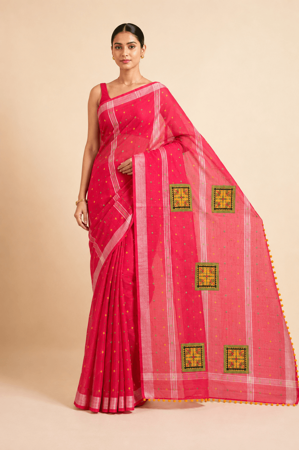 Model wearing a rani-pink georgette saree with hand-embroidered patch squares on the pallu, front view